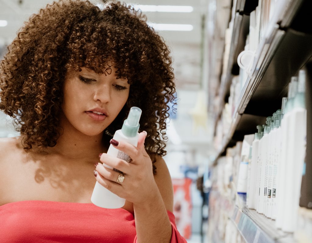 A woman looking at hair care products.
