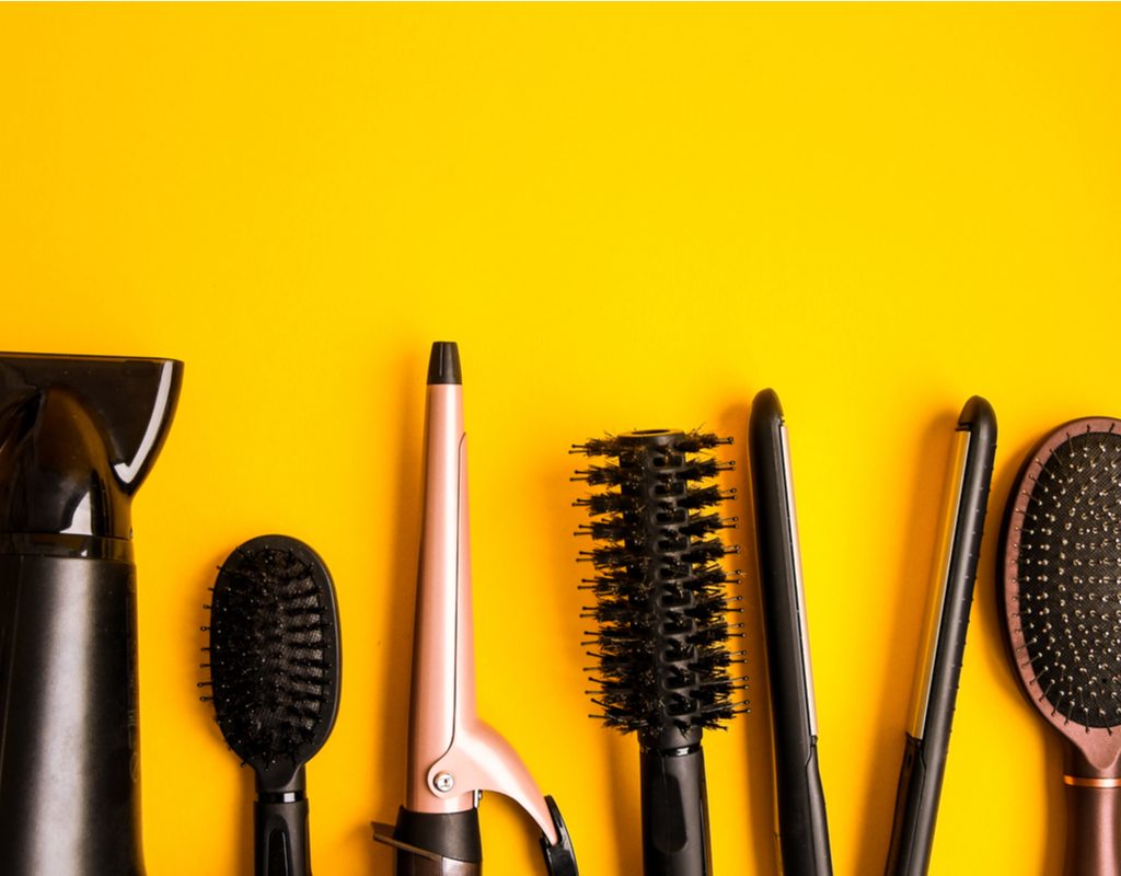 Hair styling tools on a yellow backdrop.