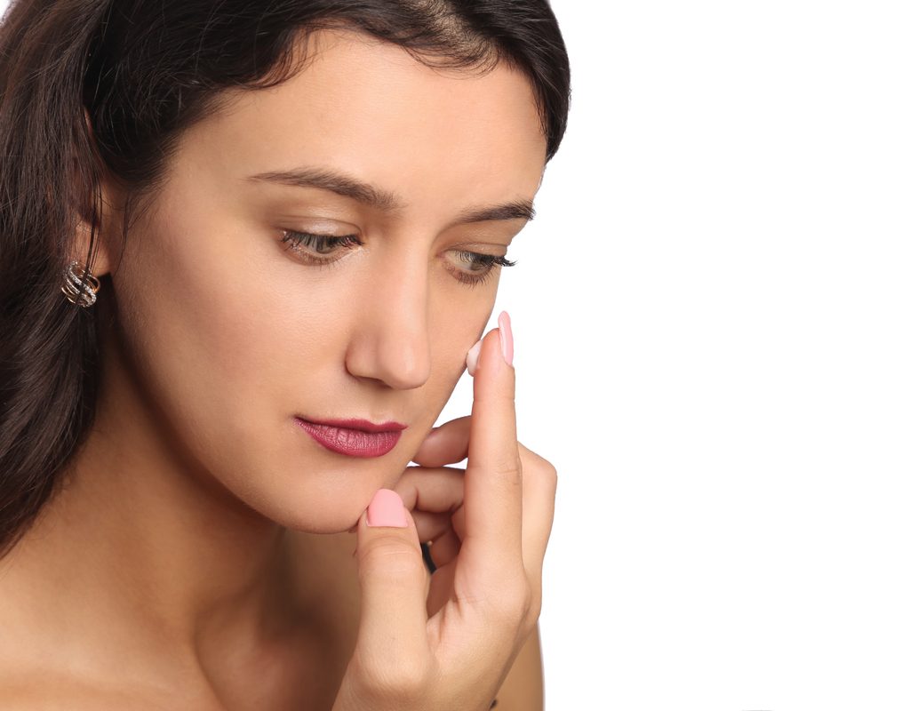 A woman putting on primer before adding her makeup.
