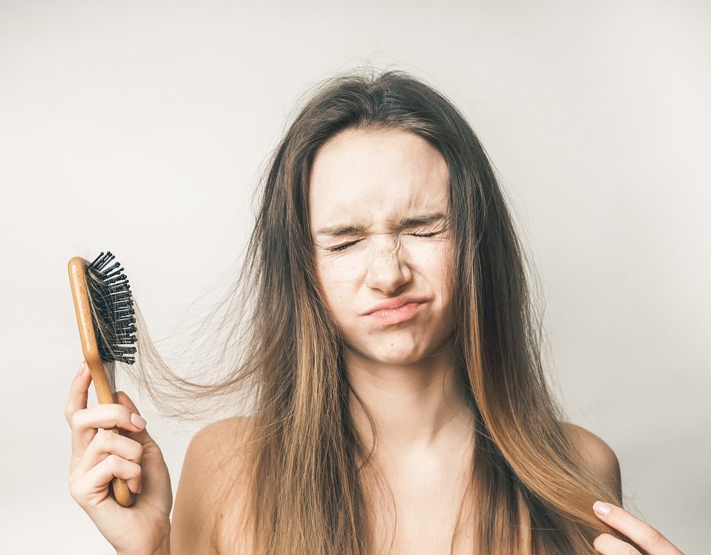 A woman brushing her hair too much.