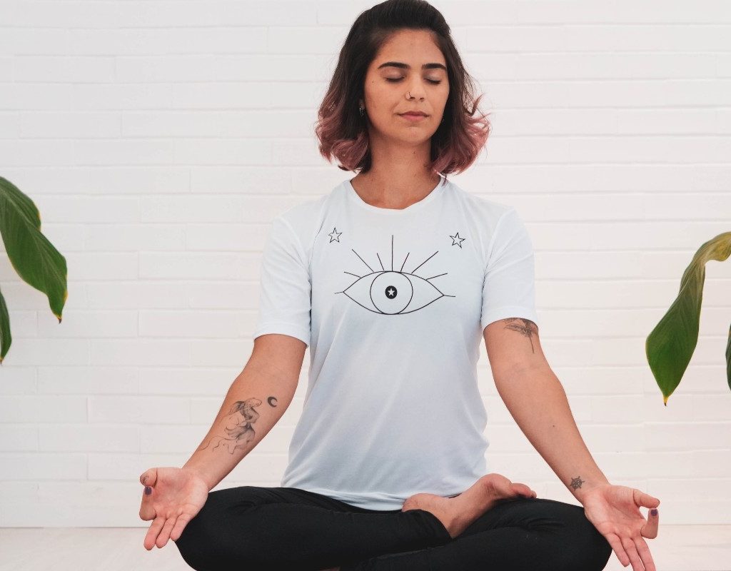 a woman sitting on a mat and breathing