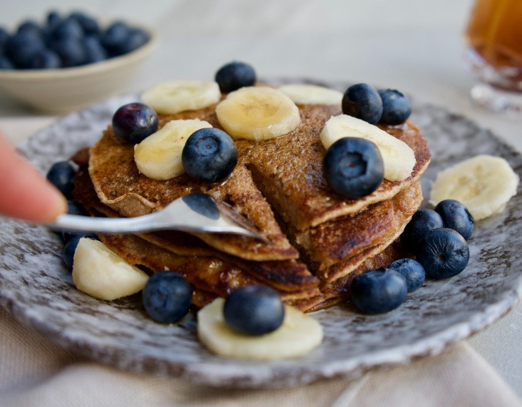 pancakes on a plate with berries and bananas