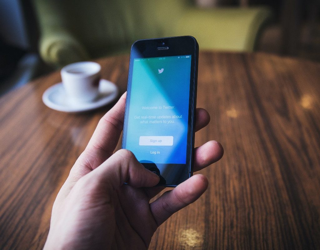 person logging into Twitter at table