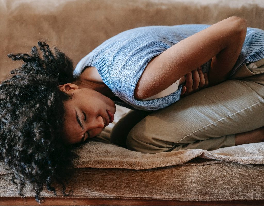 a woman on the couch with a stomach ache