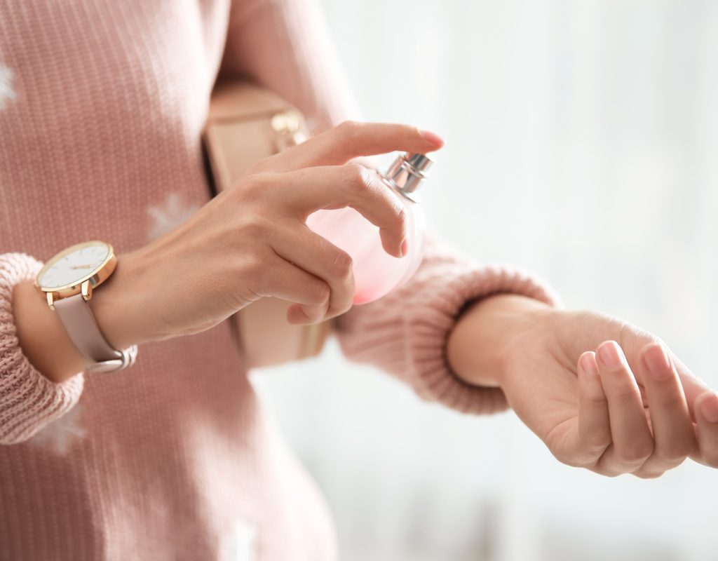 A woman applying a fragrance.