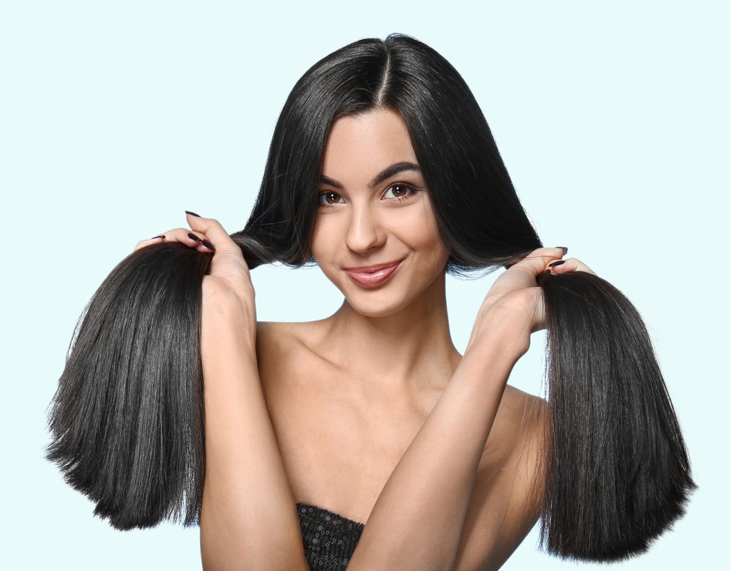 A woman holding her healthy, strong hair.