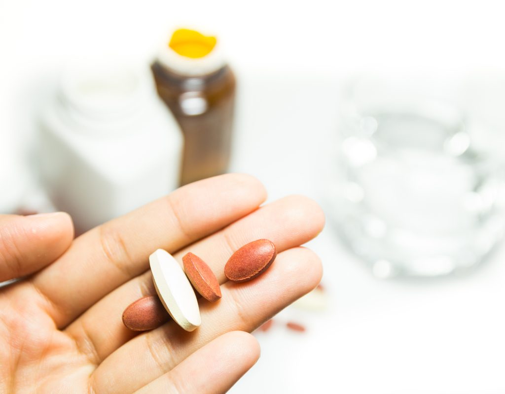 A hand holding some supplements.