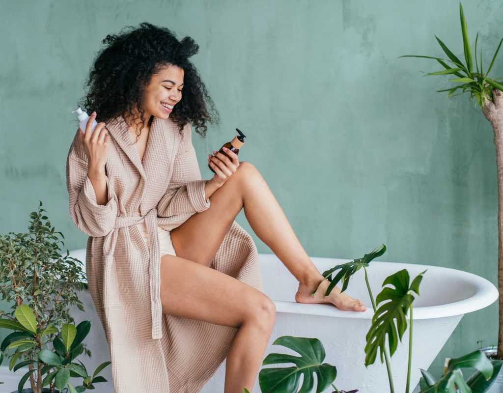 A woman deciding which lotion to put on.