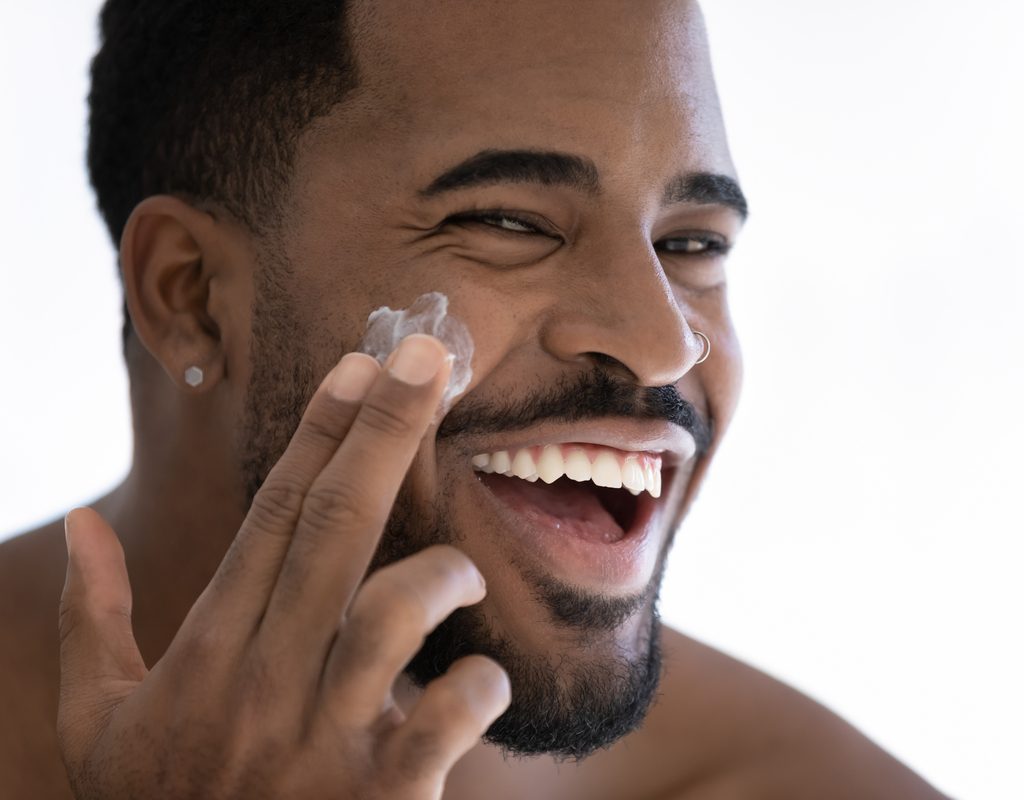 A man putting on face cream.