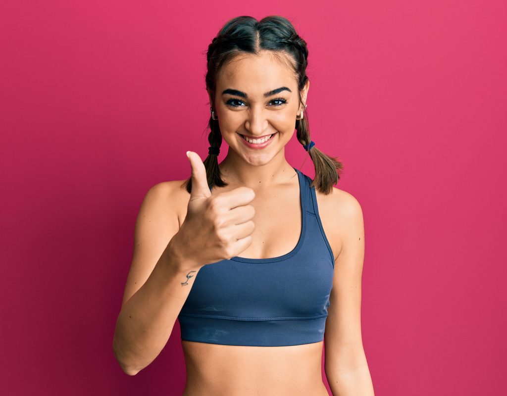A woman ready for her workout with 2 braids in her hair.