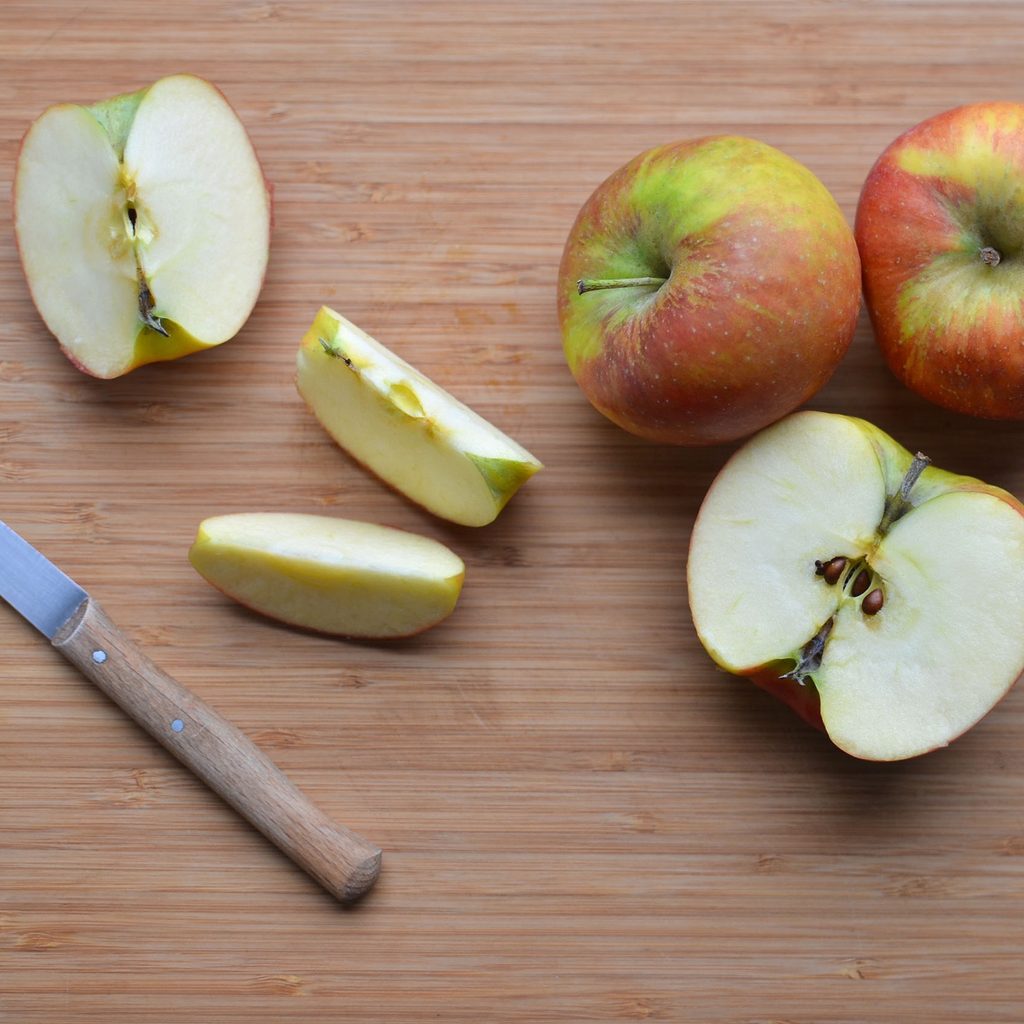 Sliced apples and knife on a cutting board