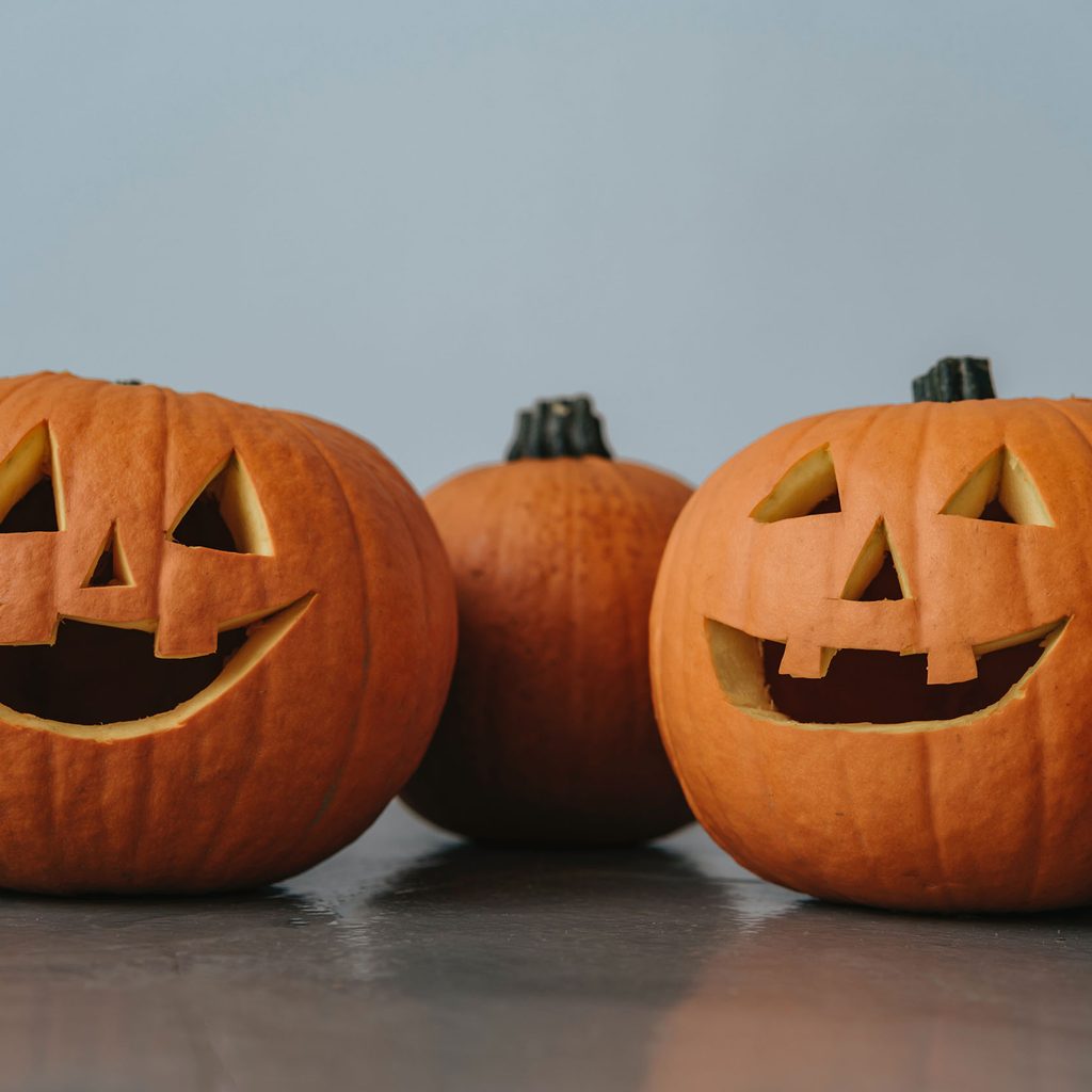 Two jack-o-lanterns and pumpkins