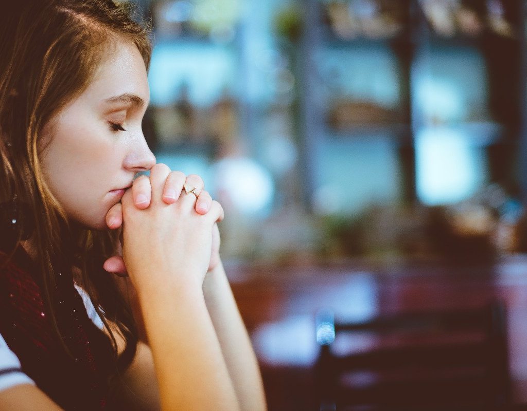a woman sitting at a restaurant and looking sad