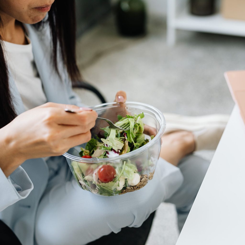 Woman eating a salad at her desk