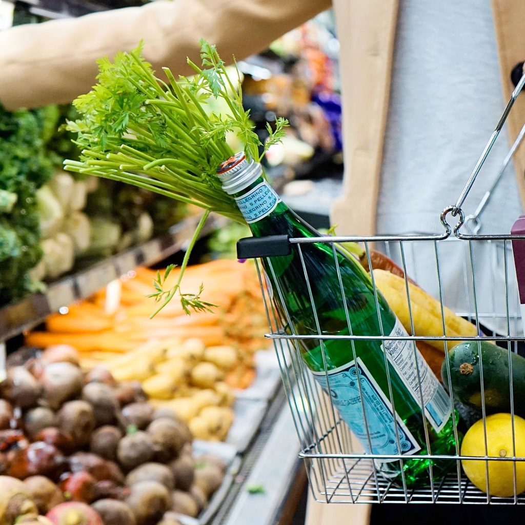 Woman grocery shopping with a full basket