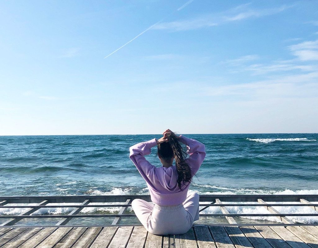 a woman sitting on a dock by water