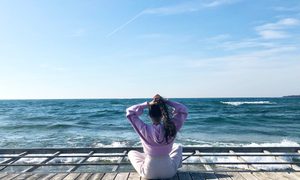 a woman sitting on a dock by water