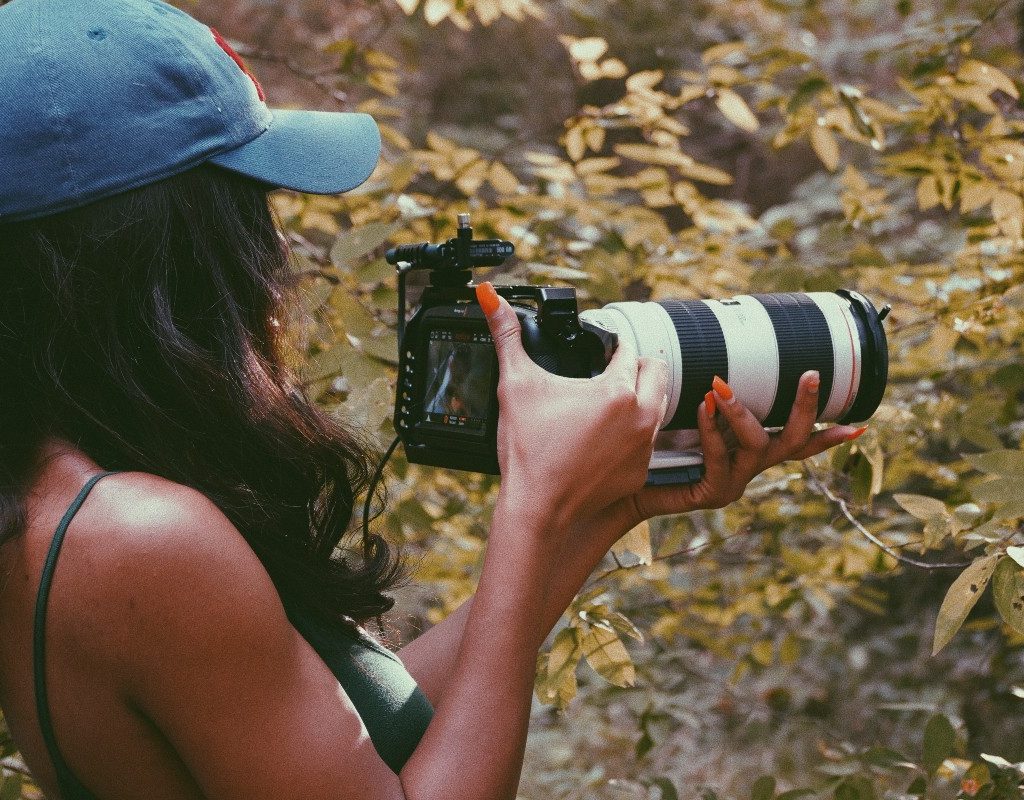 woman taking photos in woods