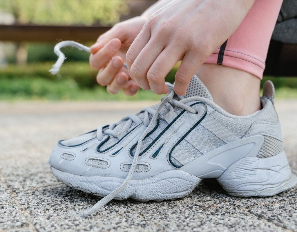 person tying shoelaces while outside