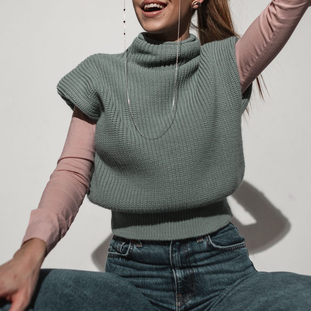 Woman wearing a sweater vest and jeans