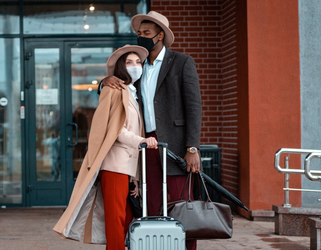a couple waiting outside of an airport
