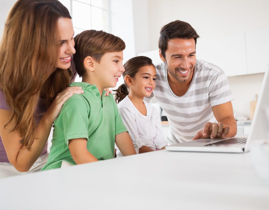 A family gathered around a computer.