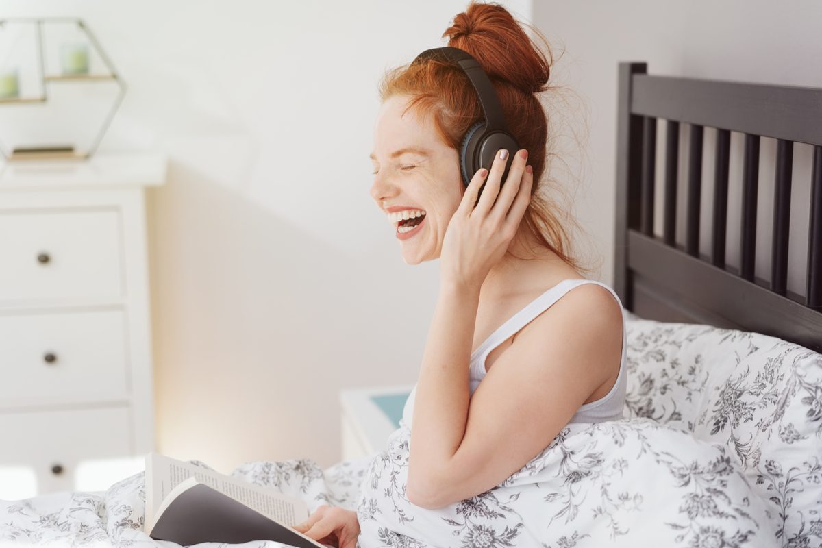 A woman listening to something funny.