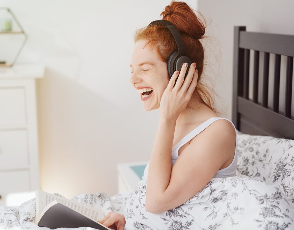 A woman listening to something funny.