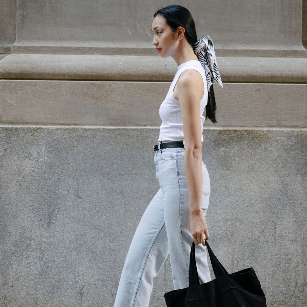 Tall woman wearing jeans and a tank top