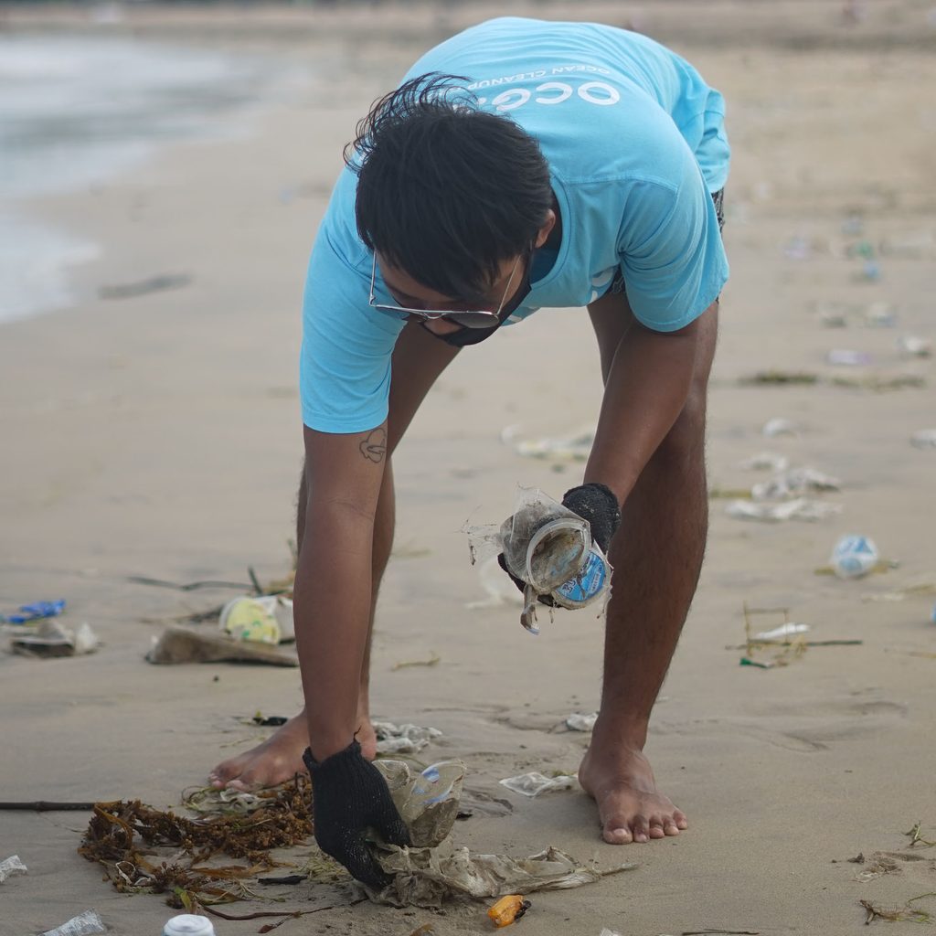 Volunteer picking up trash on the beach