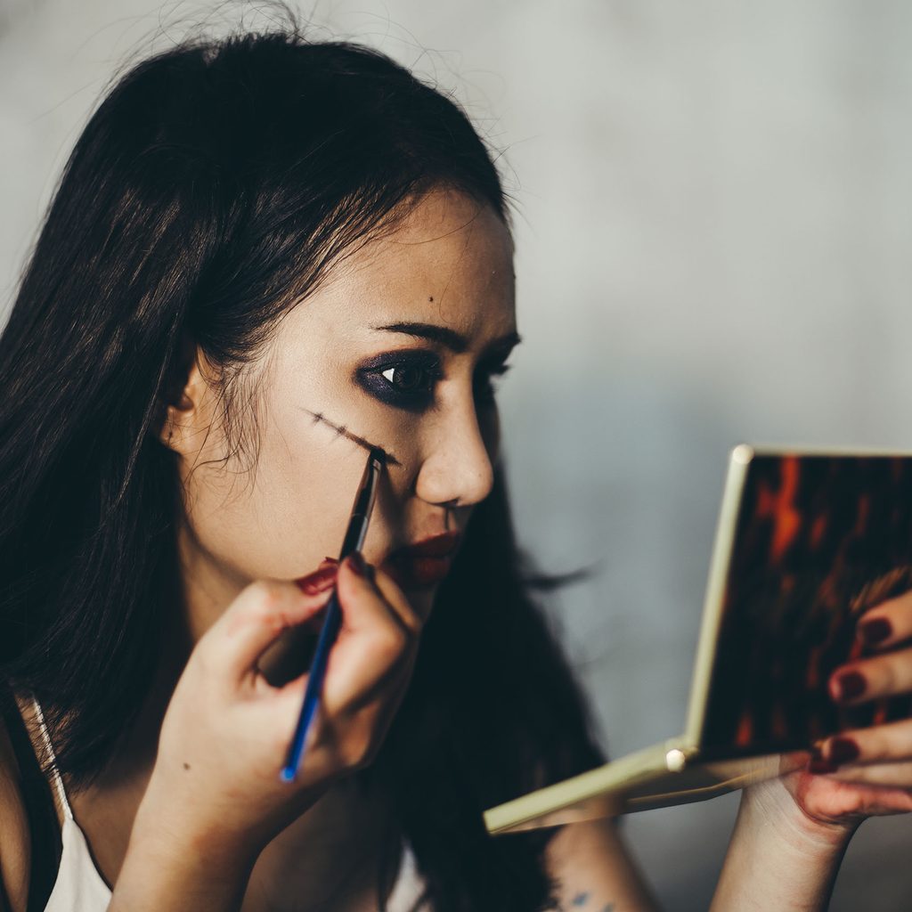 Woman applying Halloween makeup