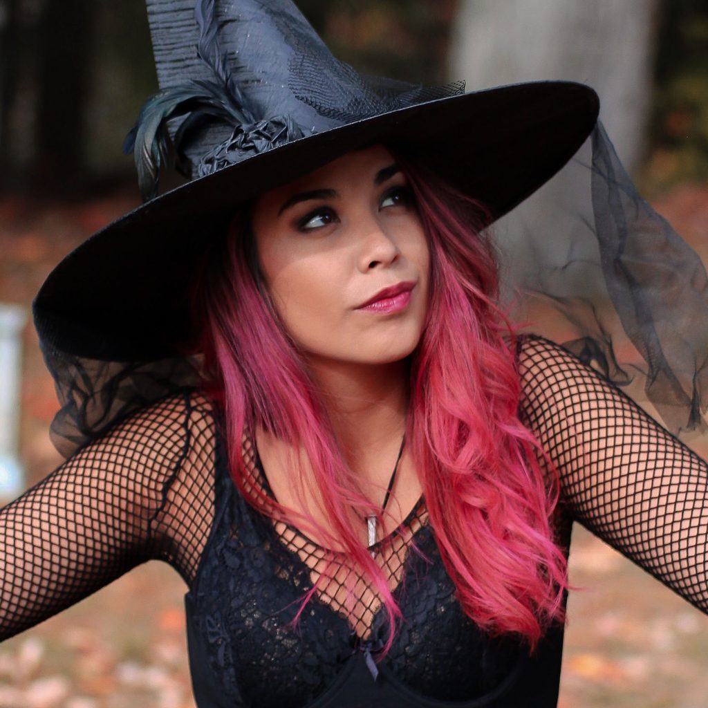 Woman with pink hair dressed as a witch