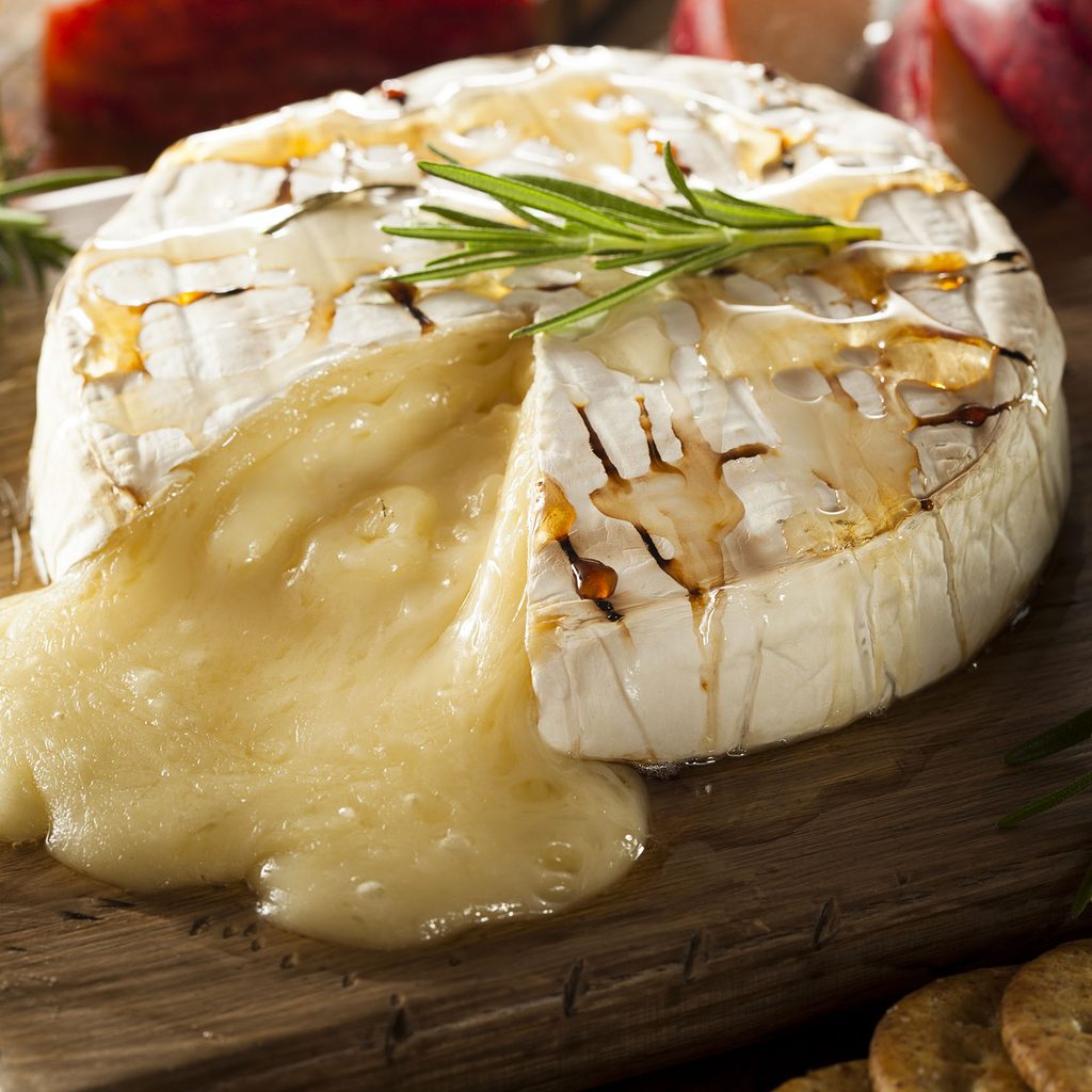 Baked brie on a wood cutting board