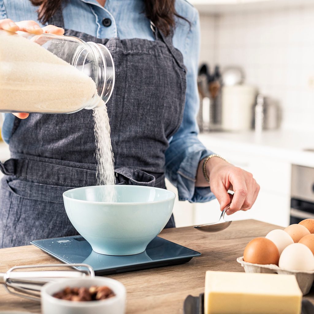 Baker weighing dry ingredient on a scale