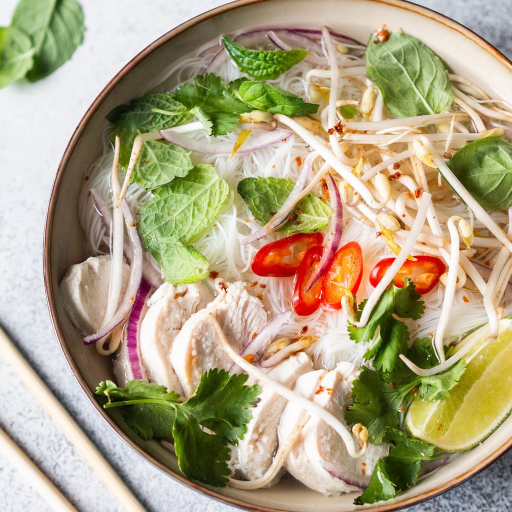 Bowl of chicken pho with chopsticks