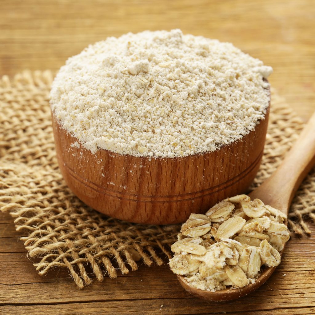 Bowl of oat flour next to oats