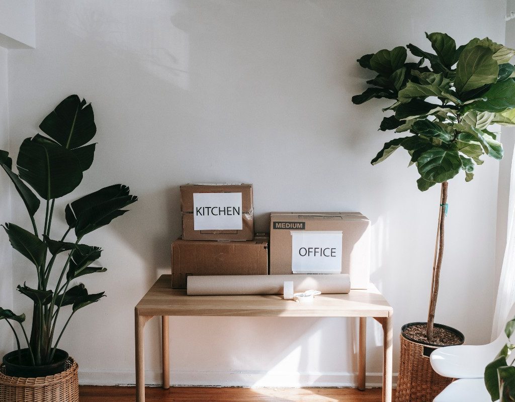 two cardboard boxes labeled "kitchen" and "office" on a wooden table