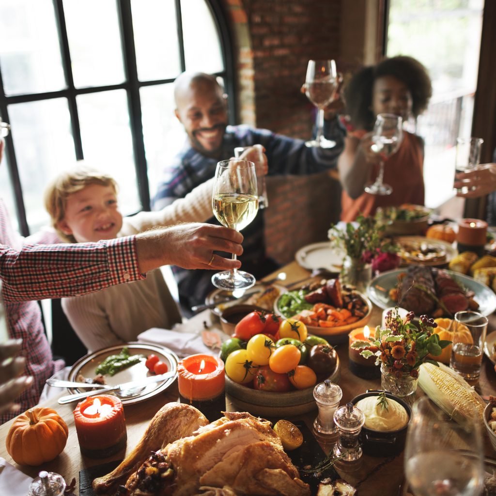 Family raising glasses at Thanksgiving table