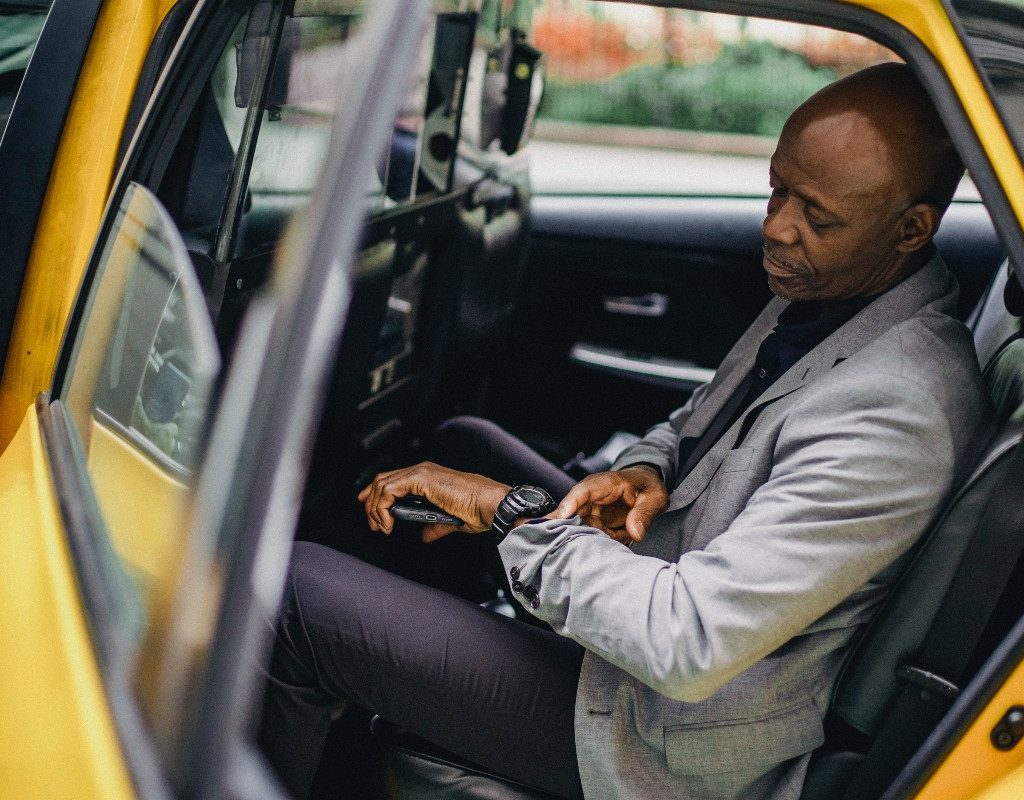 a man in a cab looking at his watch