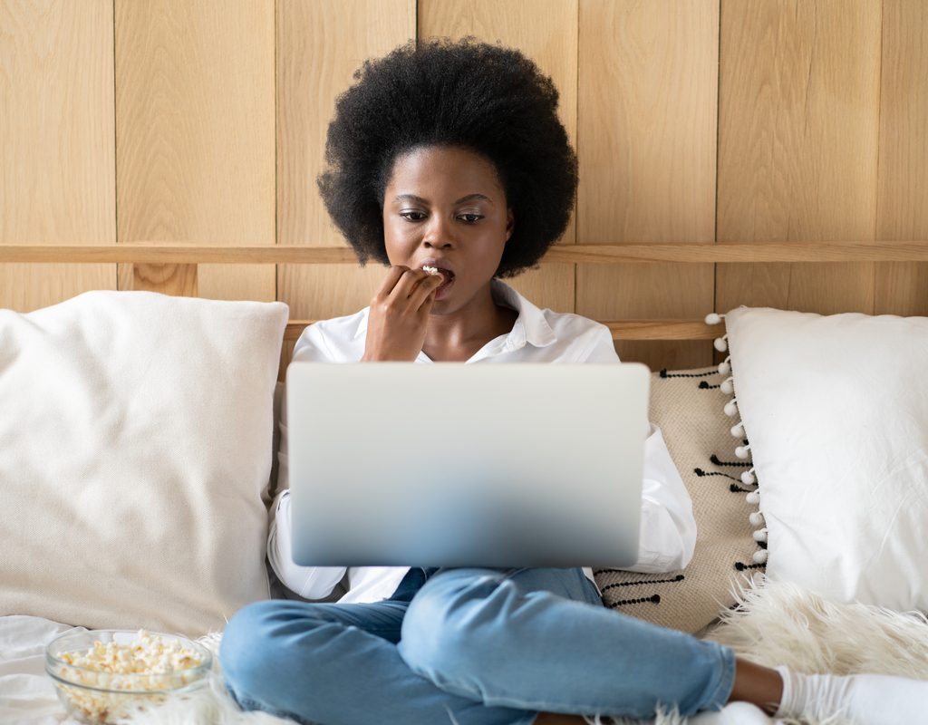 A woman watching a show on her tv.