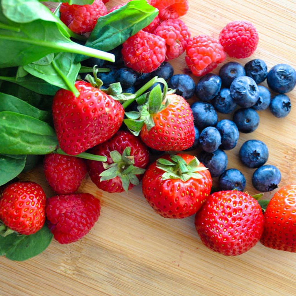 Spinach, strawberries, raspberries, and blueberries