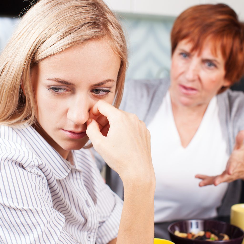 Older woman yelling at younger woman at table