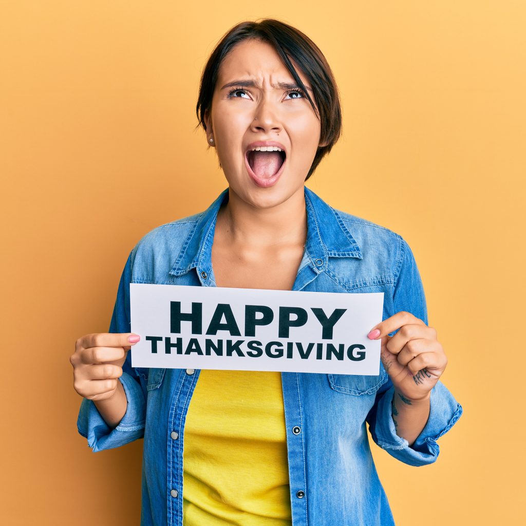 Woman screaming holding 'Happy Thanksgiving' sign