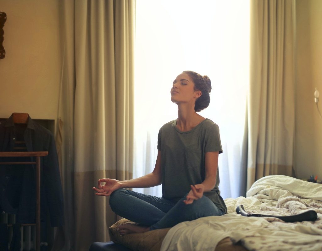 woman doing butterfly pose in bed