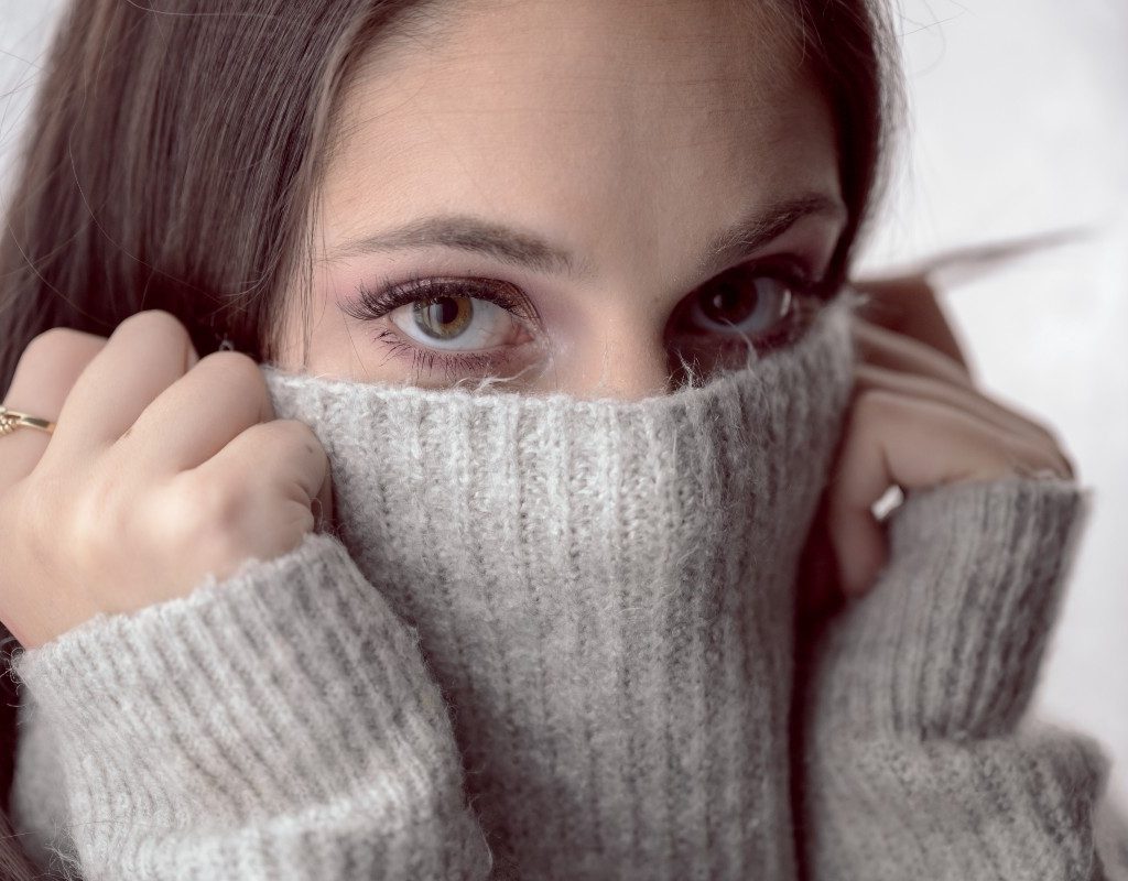 woman with a turtleneck pulled over her face