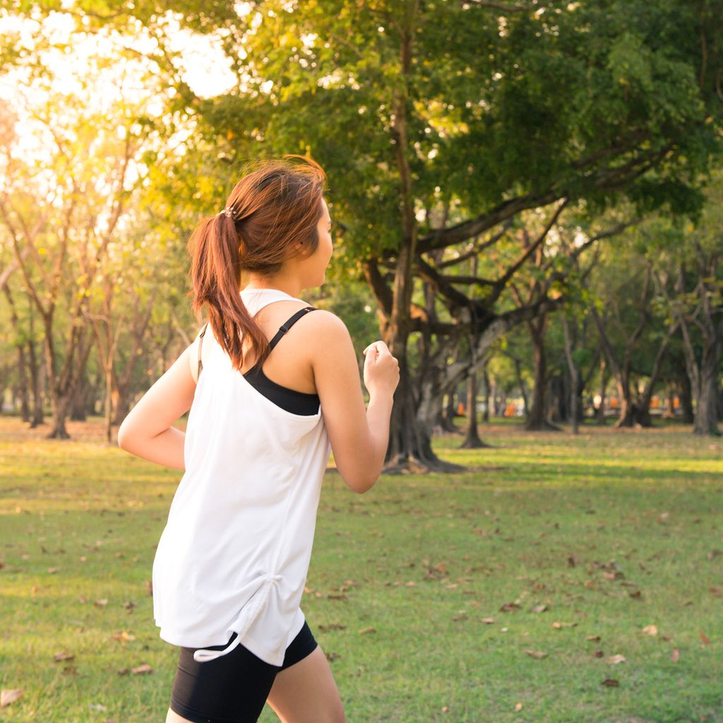 Woman running outside at sunset