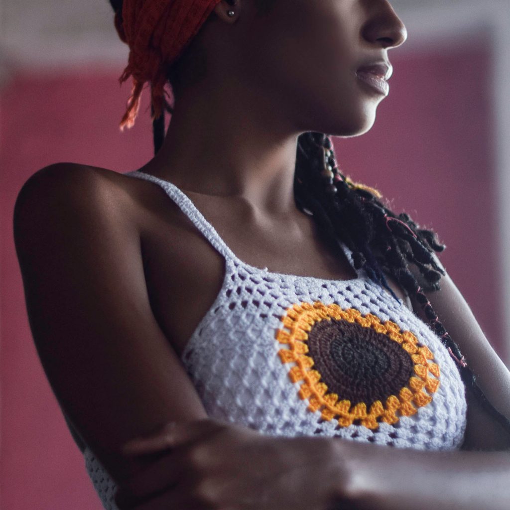 Woman wearing a crochet tank top with a sunflower on it