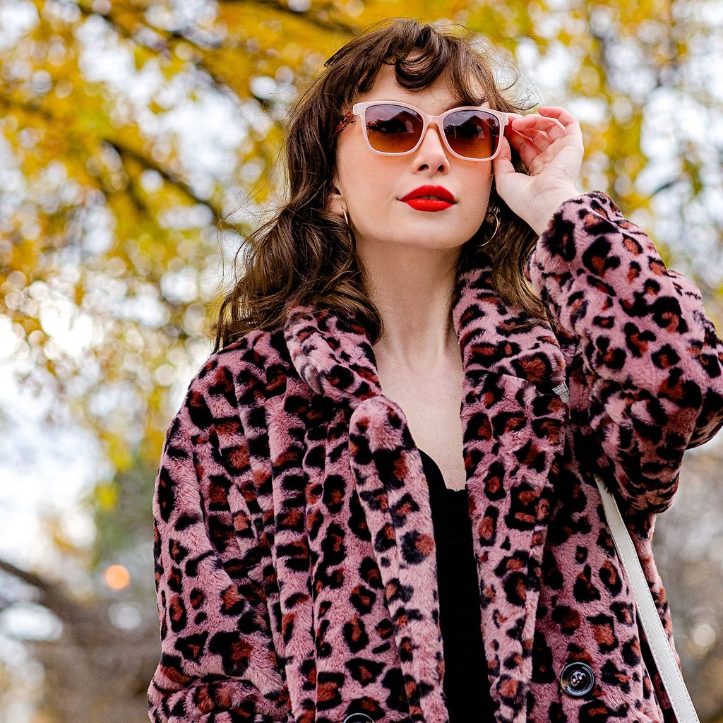 Woman wearing a faux fur pink leopard print coat