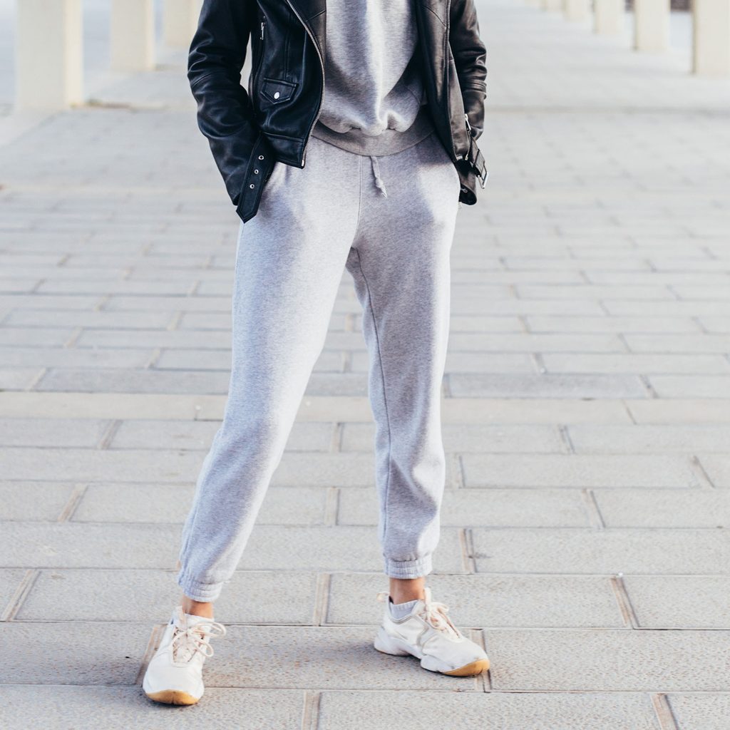 Woman wearing gray joggers with a sweatshirt and jacket