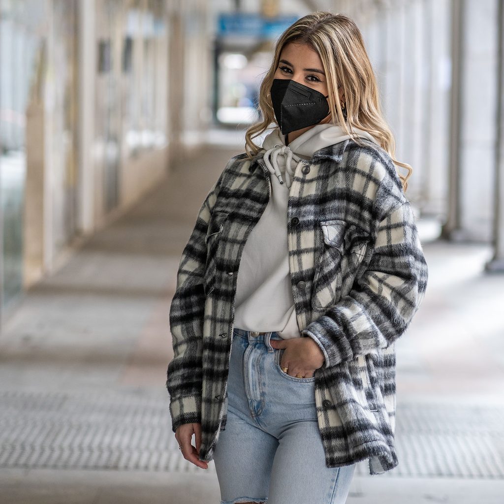 Woman wearing a plaid shacket and jeans